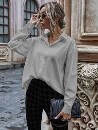 mujer con gafas de sol vistiendo una blusa gris y pantalones oscuros